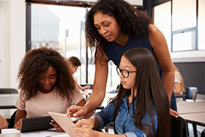 Cybersecurity - a teacher with two students on an ipad