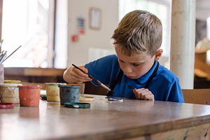 young boy in an Ironbridge Museum taking part in ceramic painting activities