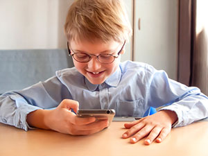 Little boy using school apps on his phone