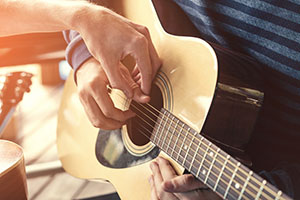 Teacher showing a guitar player how to make music