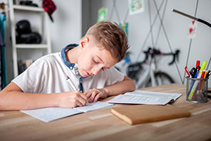 Boy doing homework without his parents