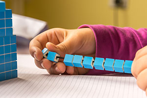 child using maths blocks on a string