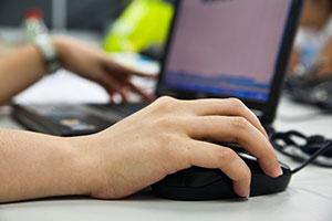 Teenage money mule accessing their bank account on the computer