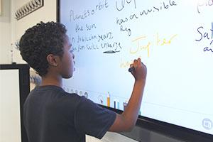 A pupil writes on the interactive flat panel by BenQ