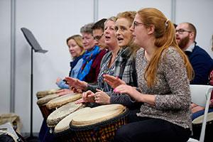 Women banging drums at the Music & Drama Education Expo