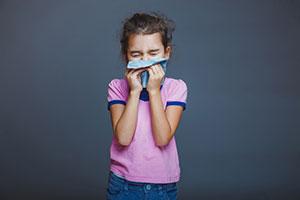 Young girl covering her mouth and nose from deadly school run risks