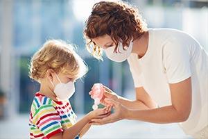 Child and parent carrying out coronavirus control measures.