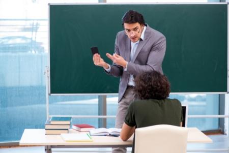 A teacher confiscating a mobile phone