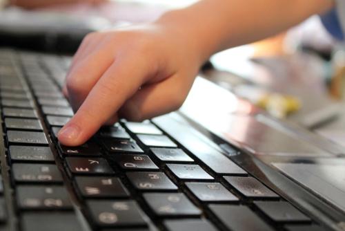 A child pressing a computer keyboard