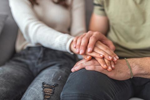 Upset people holding hands