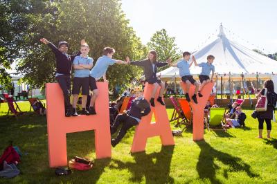 Children sitting on a Hay festival sign