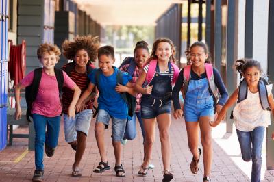 A group of happy children running at school