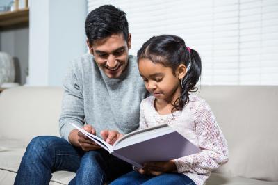 A dad reading to his daughter