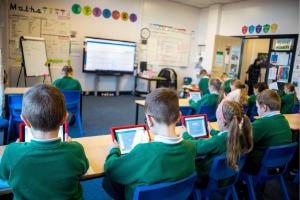 Reading Plus image of children in a classroom reading on tablet computers