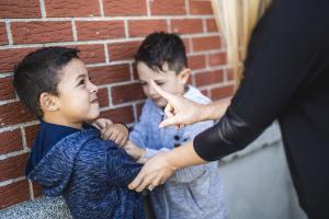 A boy being restrained by the arm