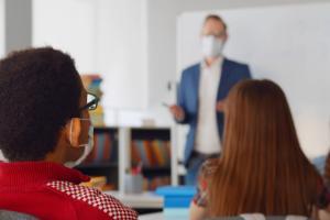 A teacher wearing a face covering in a classroom
