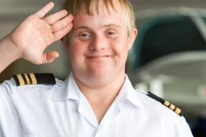 A boy wearing a captain's shirt giving a salute