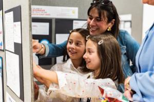 Two girls and a teacher working on a project