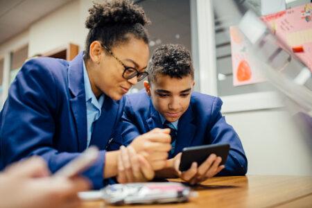 School children looking at a mobile phone