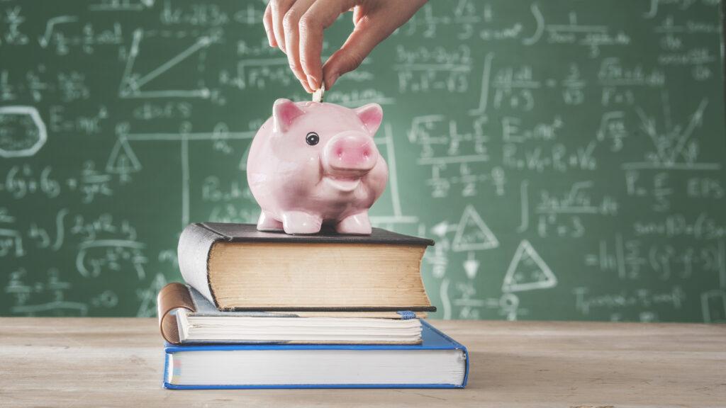School budget - a piggy bank in front of a school blackboard